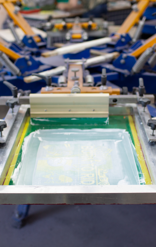 Serigrafiando una prenda con su correspondiente maquina